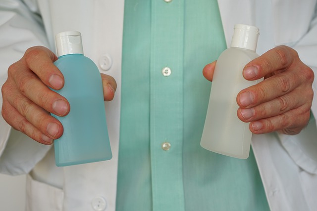 Mann hält zwei Flaschen Desinfektionsmittel vor dem Bauch